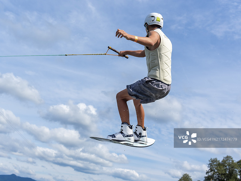 年轻男人在滑水公园玩尾波滑板、水上运动和滑水图片素材