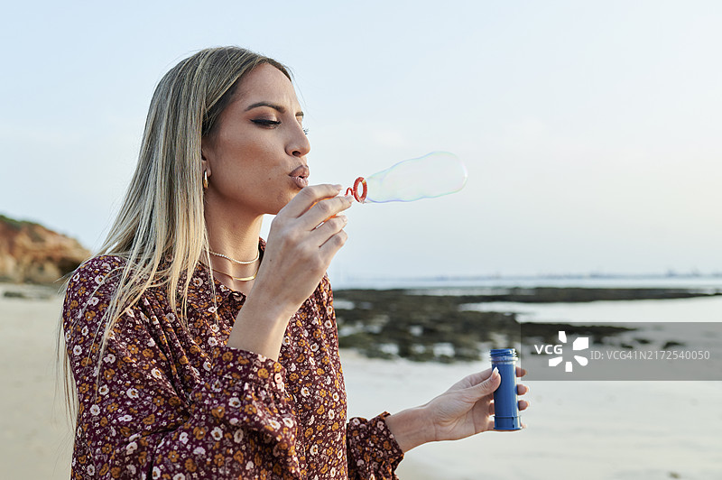 在海滩上吹泡泡的女人图片素材