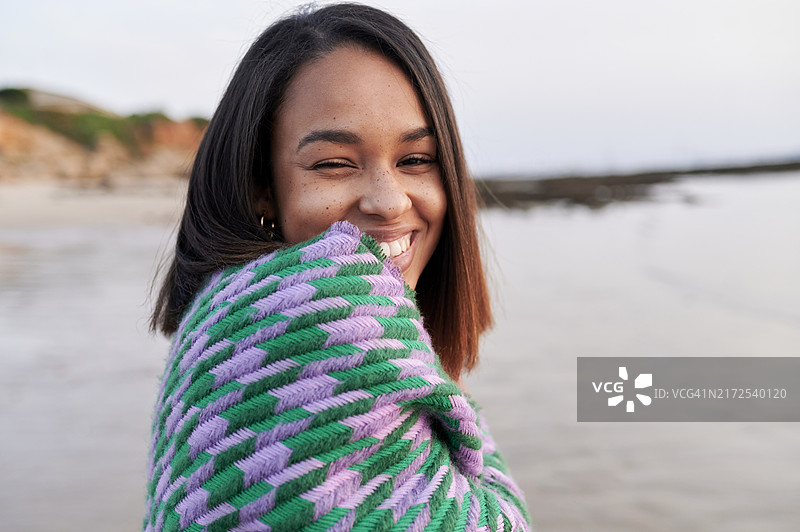 黄昏时分，海滩上戴着围巾的女性肖像图片素材