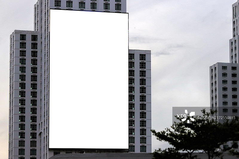 塔楼建筑上的白色竖版大型LED显示广告牌样机图片素材