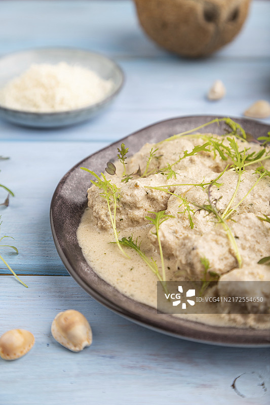 椰奶酱烩鸡柳配水菜微型蔬菜，蓝色木质背景，特写图片素材