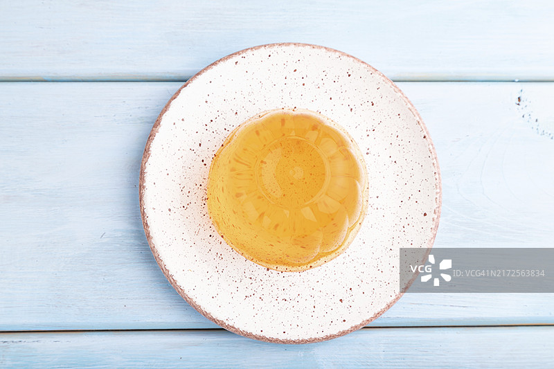 蓝色木质背景上的杏子橙色果冻，俯视，平铺，特写图片素材