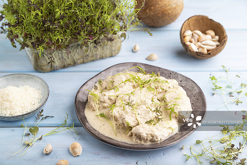 椰奶酱烩鸡柳配水菜微型蔬菜，蓝色木质背景，特写图片素材