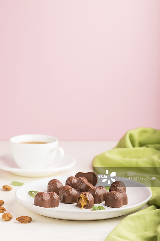 白色粉色背景杏仁巧克力焦糖糖果咖啡杯图片素材