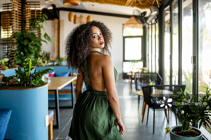 在现代咖啡馆身穿绿裙的自信女人图片素材