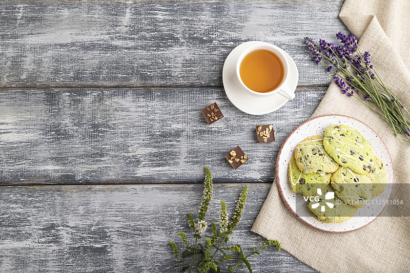 灰色木质背景上的巧克力薄荷绿色饼干与绿茶图片素材