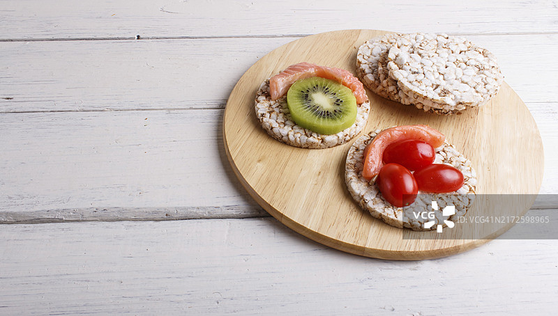 三文鱼奇异果小番茄米饼（白色木质背景，特写，留白）图片素材