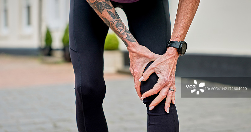 揉搓受伤膝盖的年长女性图片素材