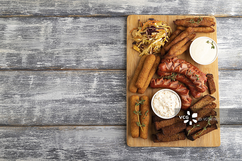 香肠鸡块芝士条等小吃砧板俯视图图片素材