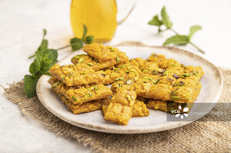 灰色水泥背景上的伊朗传统甜点Sohan与绿茶图片素材