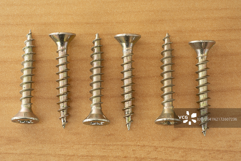 木质背景上的十字螺丝图片素材