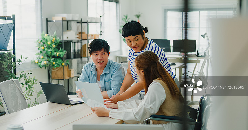 多元化的办公室团队讨论可持续性和企业责任，其中一位成员坐在轮椅上，ESG可持续商业办公室图片素材