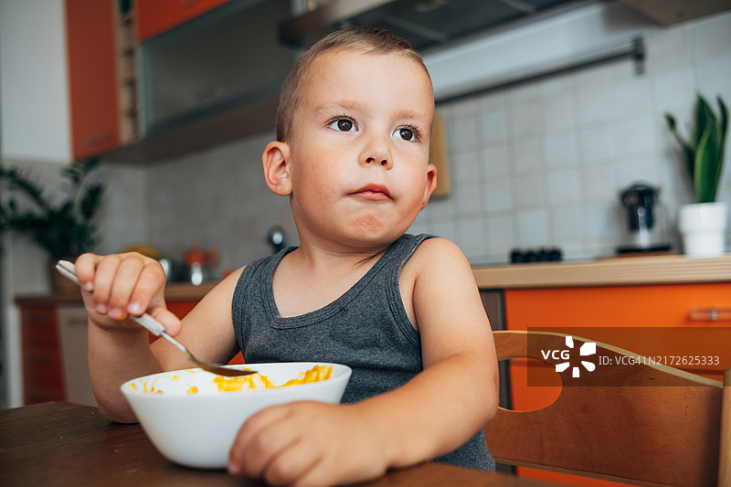 儿童在家中餐桌旁吃南瓜汤的肖像图片素材
