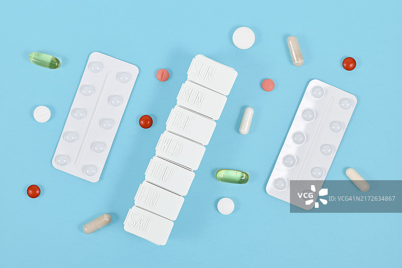 蓝色背景上的药丸、胶囊、泡罩包装和药盒图片素材