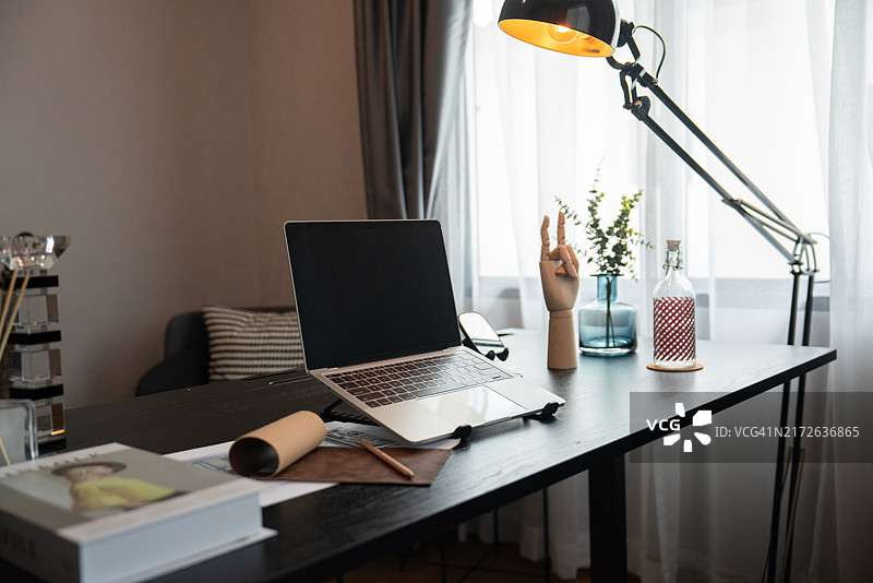 带笔记本电脑和台灯的舒适家庭办公室桌图片素材