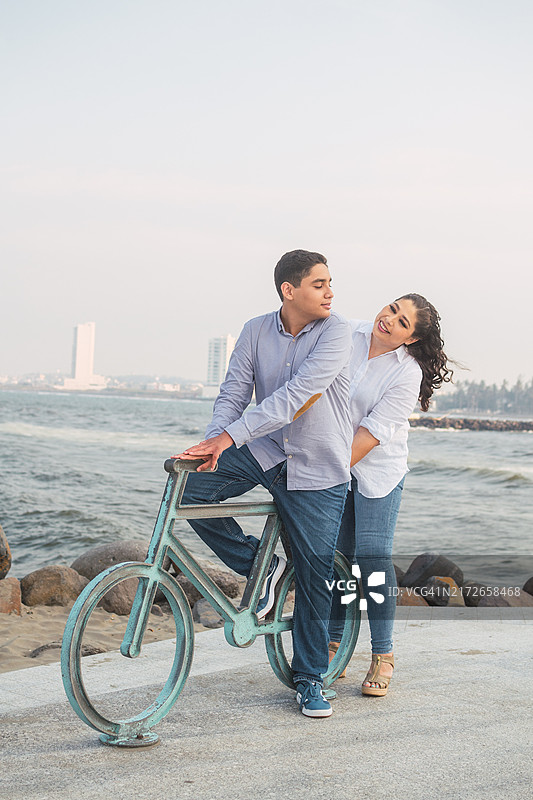 拉丁裔母亲与青少年儿子沙滩玩耍图片素材