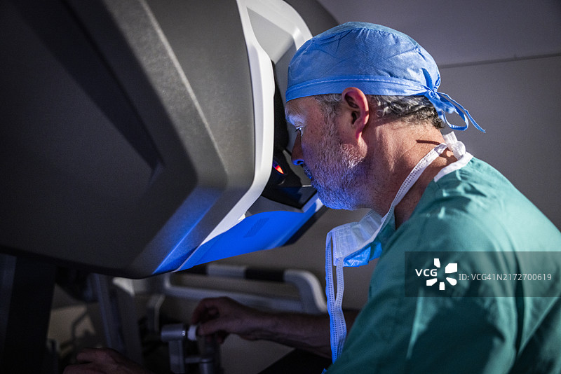 坐在手术机器人控制台前的外科医生图片素材