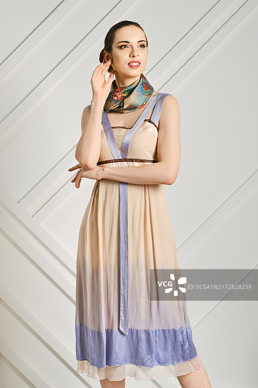 梦幻的年轻女人，双手交叉戴着丝巾图片素材