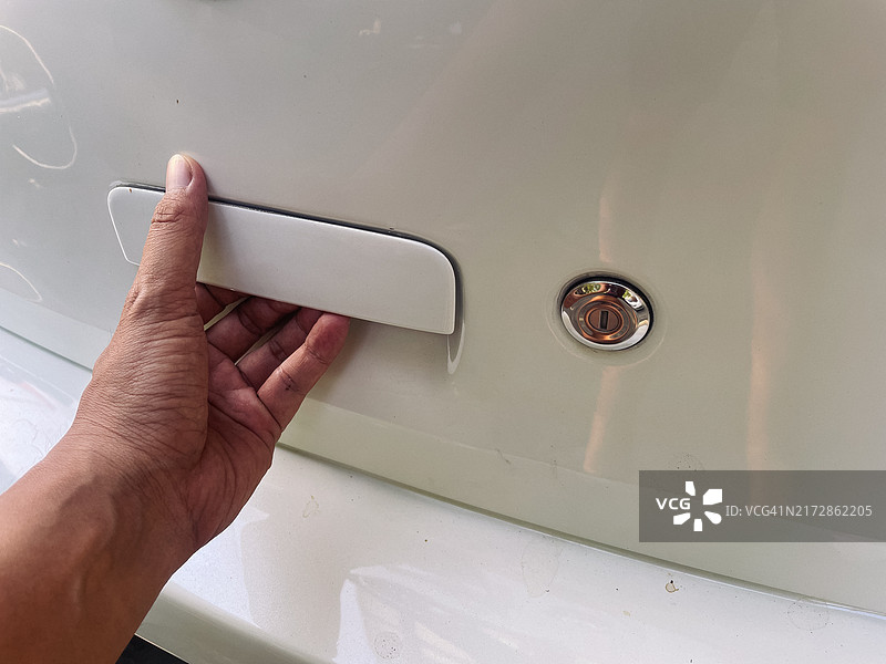 男人的手放在白色后车门把手上图片素材