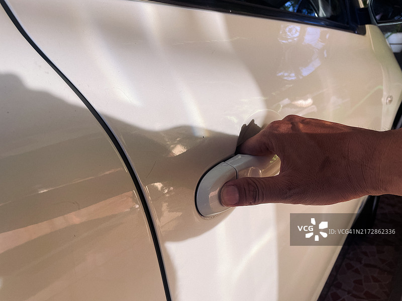 男人手在白色汽车门把手上图片素材