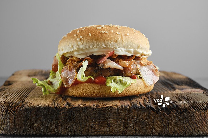 木质背景上的培根牛肉汉堡图片素材