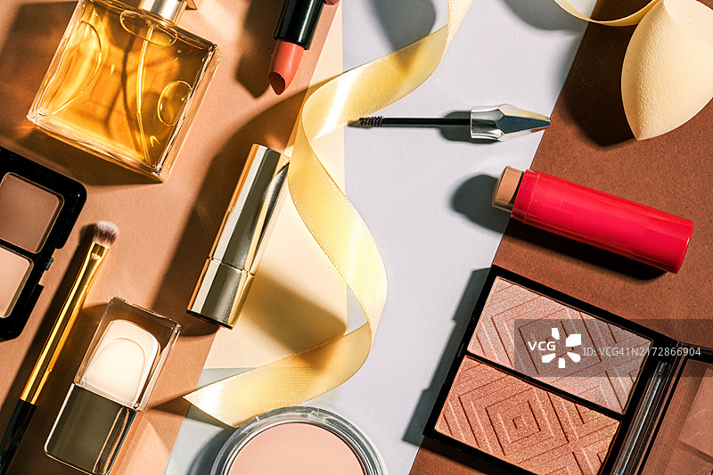 女士化妆品套装：化妆刷、管状口红、腮红盘、眼影、眉毛膏、香水、指甲油、眼影盘、粉饼和化妆海绵图片素材