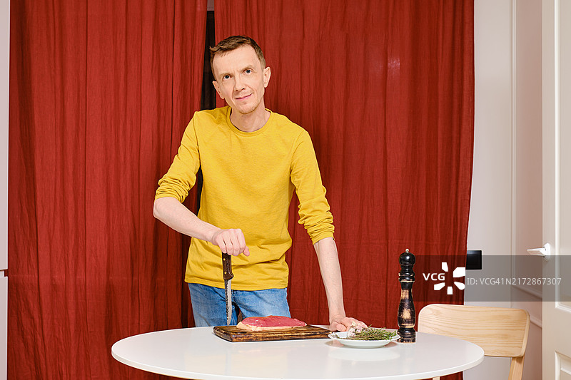 倚靠在刀上，准备做鸭胸肉的中年男人图片素材