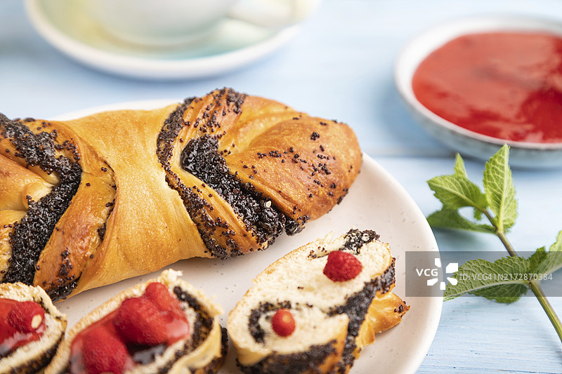 蓝色木质背景上的自制草莓酱甜面包和绿茶，侧视图，特写，选择性聚焦图片素材