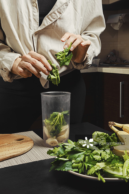 女士将菠菜放入搅拌机图片素材