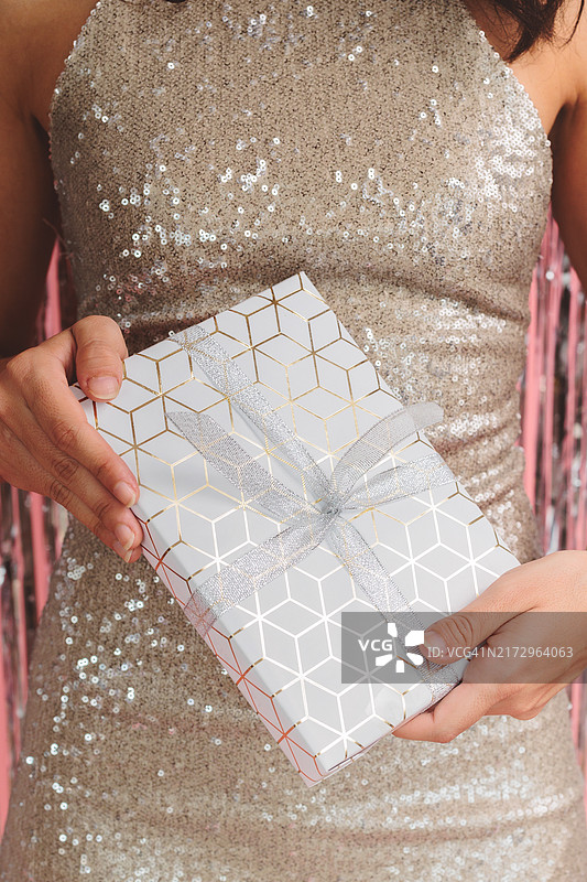 身穿优雅连衣裙手持圣诞礼盒的女子图片素材