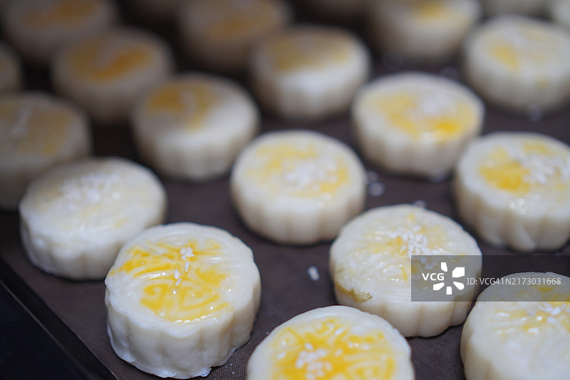 月饼、中式酥皮糕点、咸蛋黄豆饼、泰式绿豆糕和黑芝麻鸡蛋蛋糕，置于不锈钢烤架上图片素材