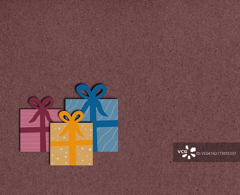 三只彩色礼品盒，棕色背景，带丝带与图案图片素材