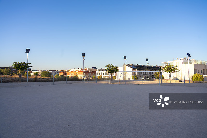 城市住宅区内采用太阳能照明的足球场视角，强调可再生能源与城市运动空间的结合图片素材
