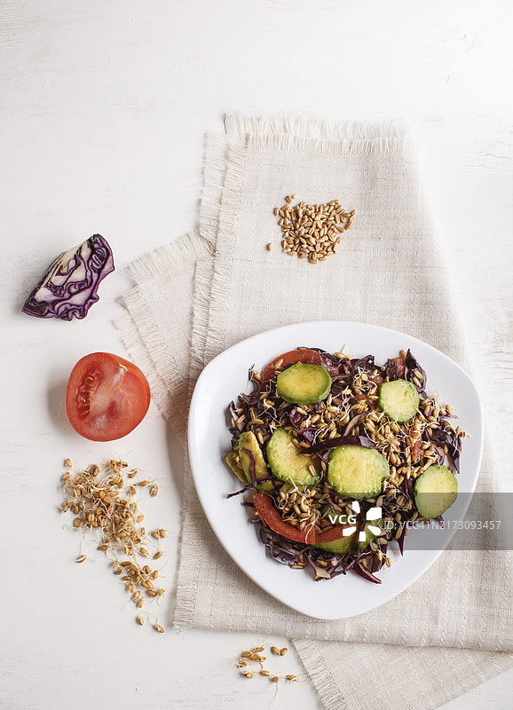 紫色卷心菜、小麦胚芽、西红柿和鳄梨亚麻桌布素食沙拉，白色背景，顶视图，复制空间图片素材