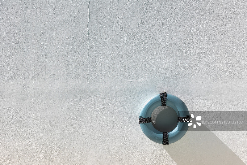 蓝色救生圈装饰挂在白色乡村风格的墙上图片素材