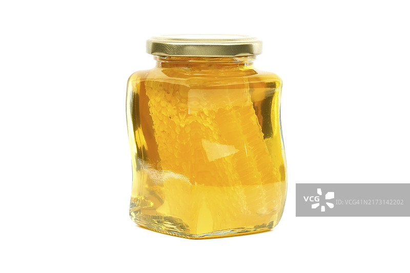 装满蜂蜜和蜂巢的金色盖子玻璃罐图片素材