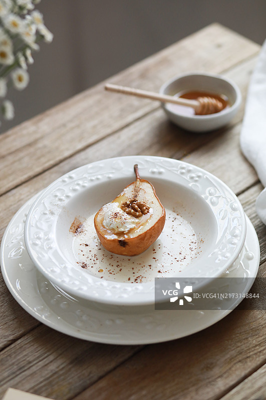 蜂蜜烤梨配冰淇淋、核桃、肉桂和香料图片素材