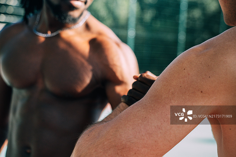 象征团队合作与支持的两名不同肤色的朋友牵手图片素材