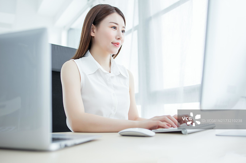 自信的女商人，在现代办公室用电脑工作图片素材