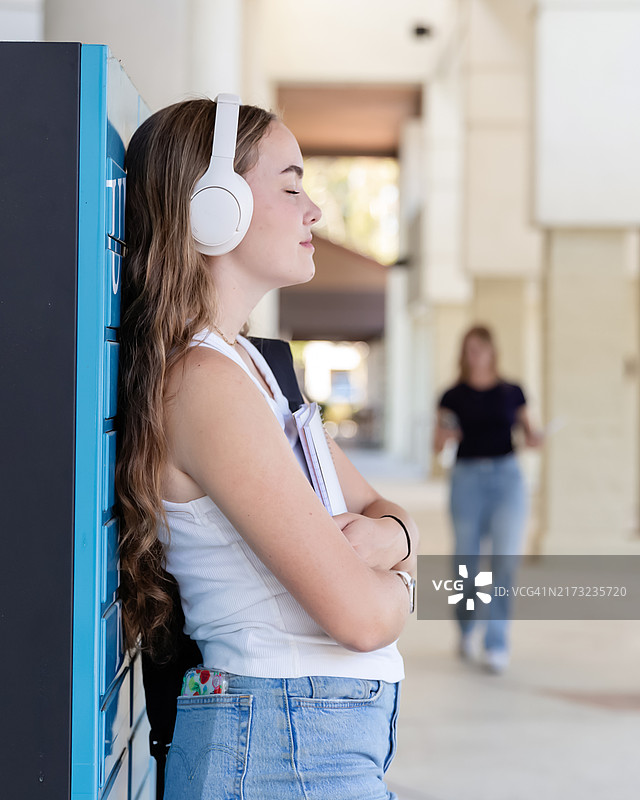 少女在储物柜旁休息，放松心情图片素材