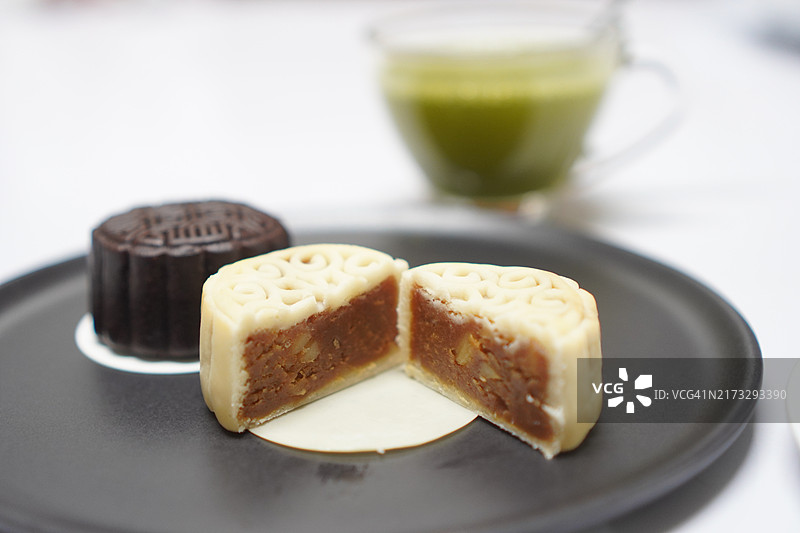 月饼、中式酥皮点心、咸蛋黄豆饼、泰式绿豆蛋饼配黑芝麻和抹茶图片素材