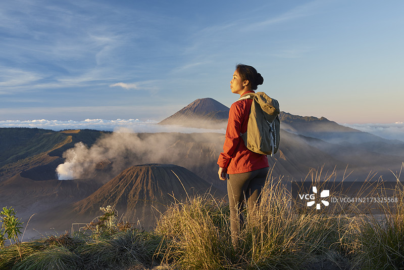 年长的亚洲女游客在布罗莫火山前欣赏日出图片素材