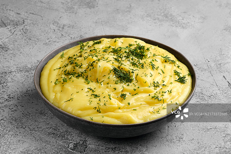 抽象混凝土背景上的土豆泥陶瓷盘图片素材