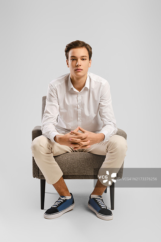 坐在扶手椅上的沉思的年轻男子图片素材