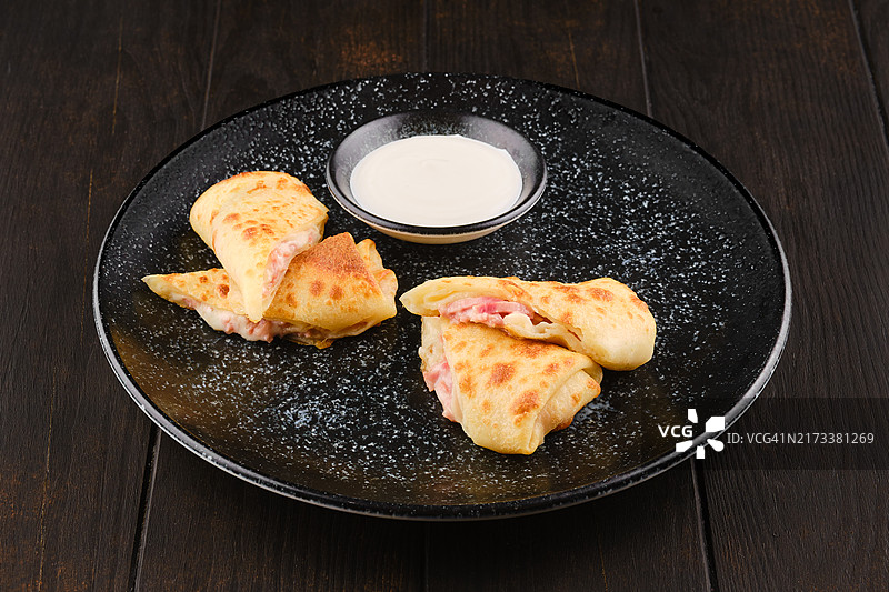 夹着火腿和奶酪的薄可丽饼，切成两半图片素材