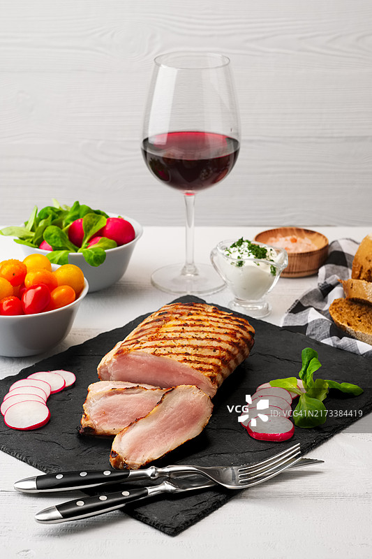 烤猪里脊片配新鲜番茄和萝卜，佐以红酒图片素材
