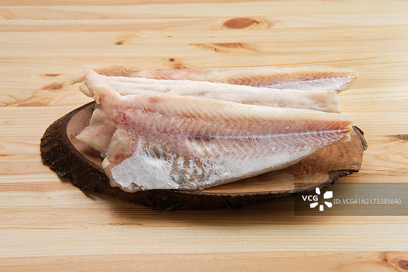 木桌上的冷冻巴沙鱼片图片素材