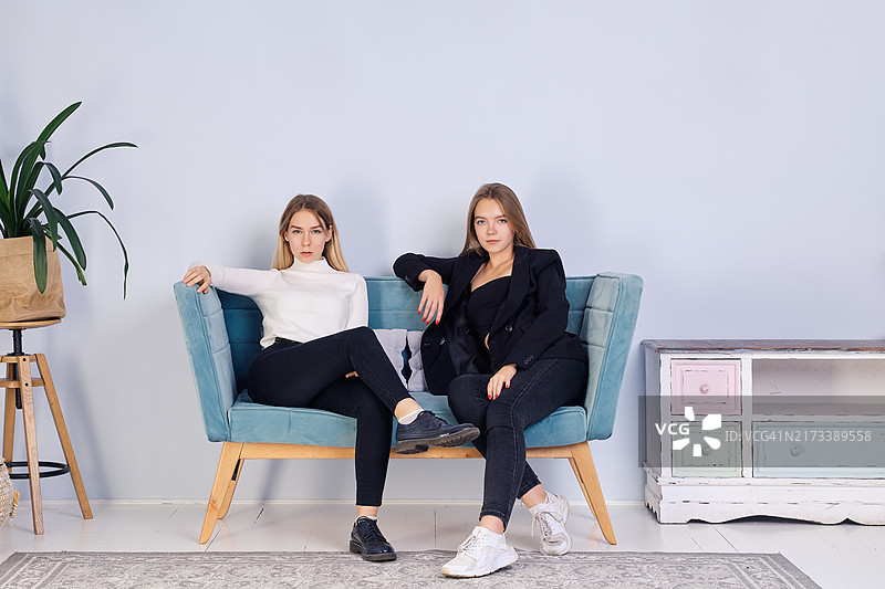 两个女孩一起坐在沙发上，友谊和青少年关系图片素材
