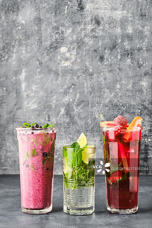 三杯水果清爽饮品，灰色背景图片素材
