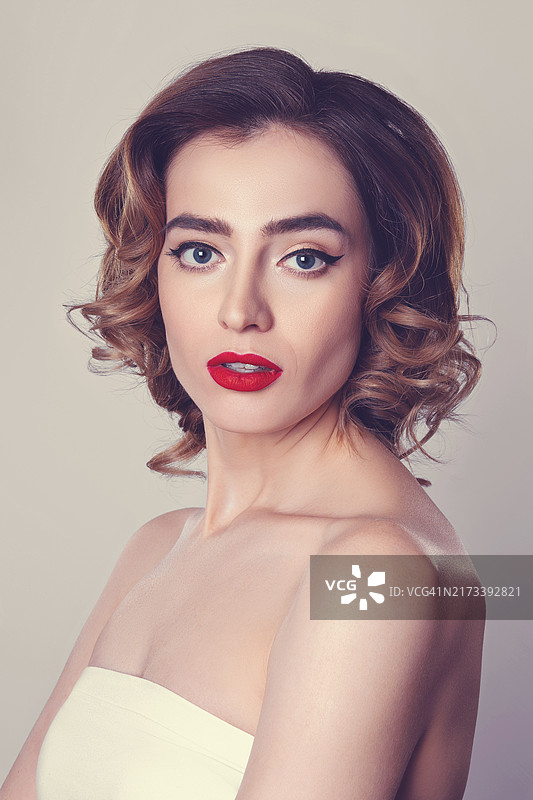 卷发美女的精美肖像，猫眼妆，红唇，医疗保健图片素材